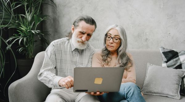 A senior couple looking at a computer trying to decide which incontinence product is right for them